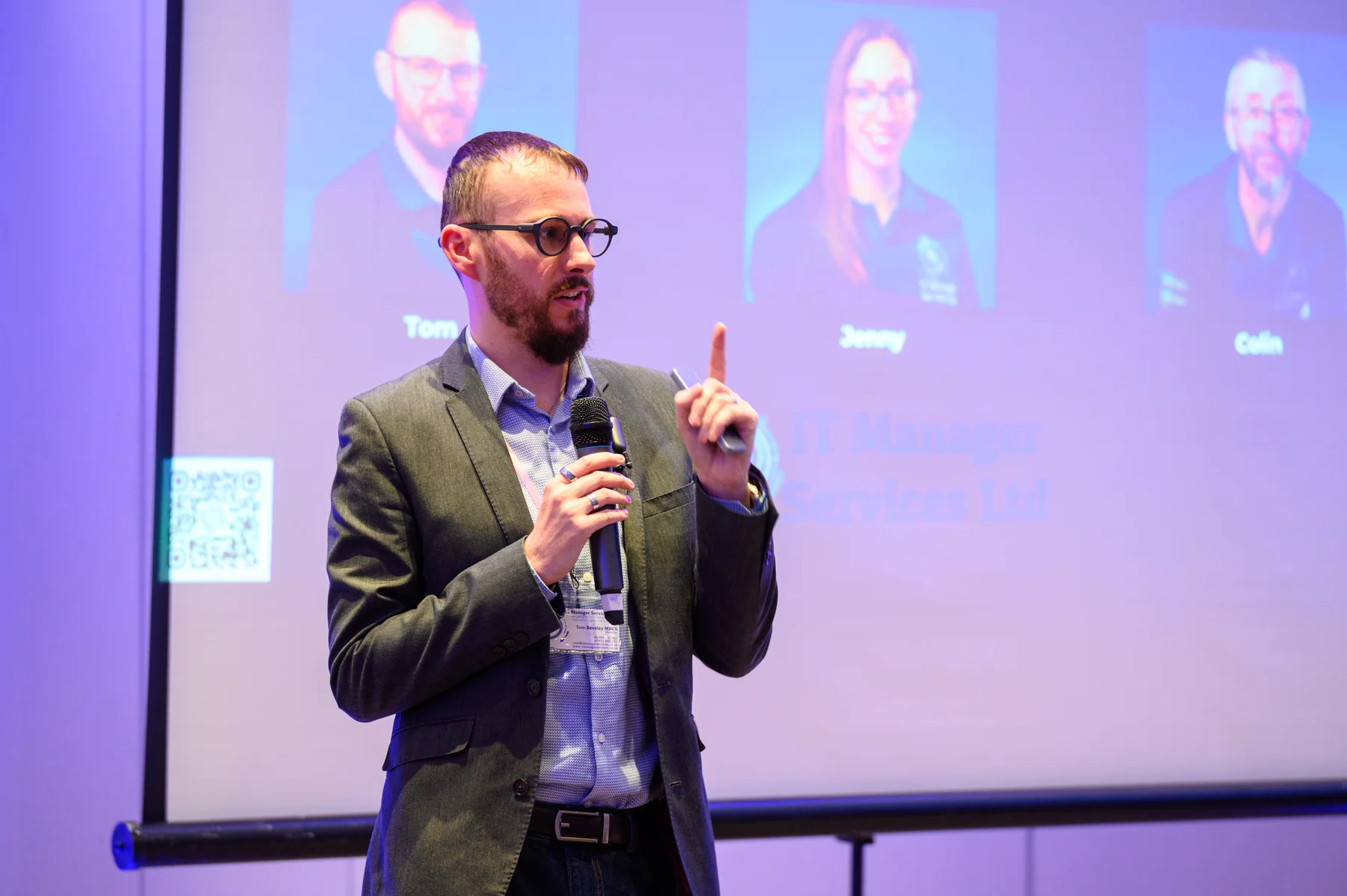 Tom speaking into a microphone at the AIMS Conference